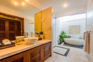 Ein modernes Badezimmer mit einem großen Spiegel, zwei Waschbecken, einer Badewanne und einer Duschkabine.