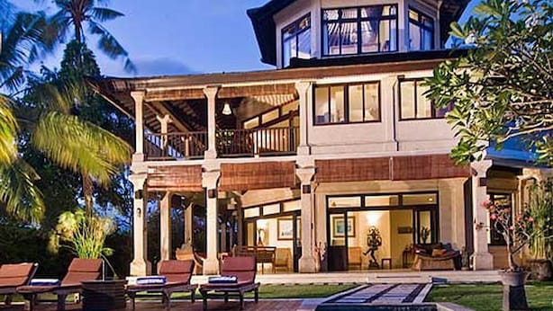 A large, multi-story building with a pool in the foreground.
