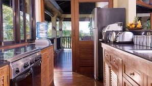 A kitchen with a stove, refrigerator, and a water dispenser.