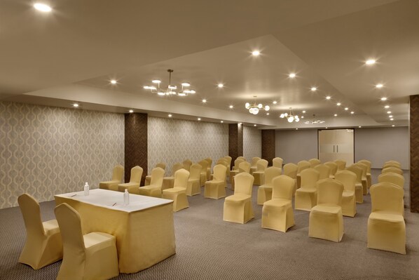 A conference room with rows of chairs, a table, and ceiling lights. - Click Hotel Jaipur, Raja Park (Jaipur)