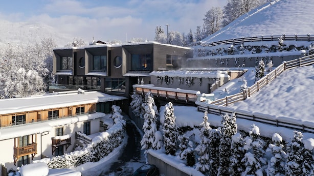 A modern ski resort with a snow-covered landscape, wooden buildings, and a ski lift. - Sporthotel Wagrain (Wagrain)