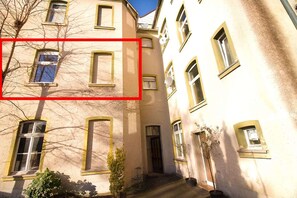 A multi-story building with multiple windows and balconies. - T1-Apartment-1.OG-HH (Bergisch Gladbach)