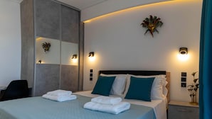A modern hotel room with a large bed, a wardrobe, and bedside lamps. - AR apartment (Πλατανίδια)
