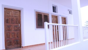 A building with a wooden door, a window with shutters, and a white railing. - Mele Sky Beach, BEACH APARTMENT, sea views, terrace and sun (Lomo Quiebre)