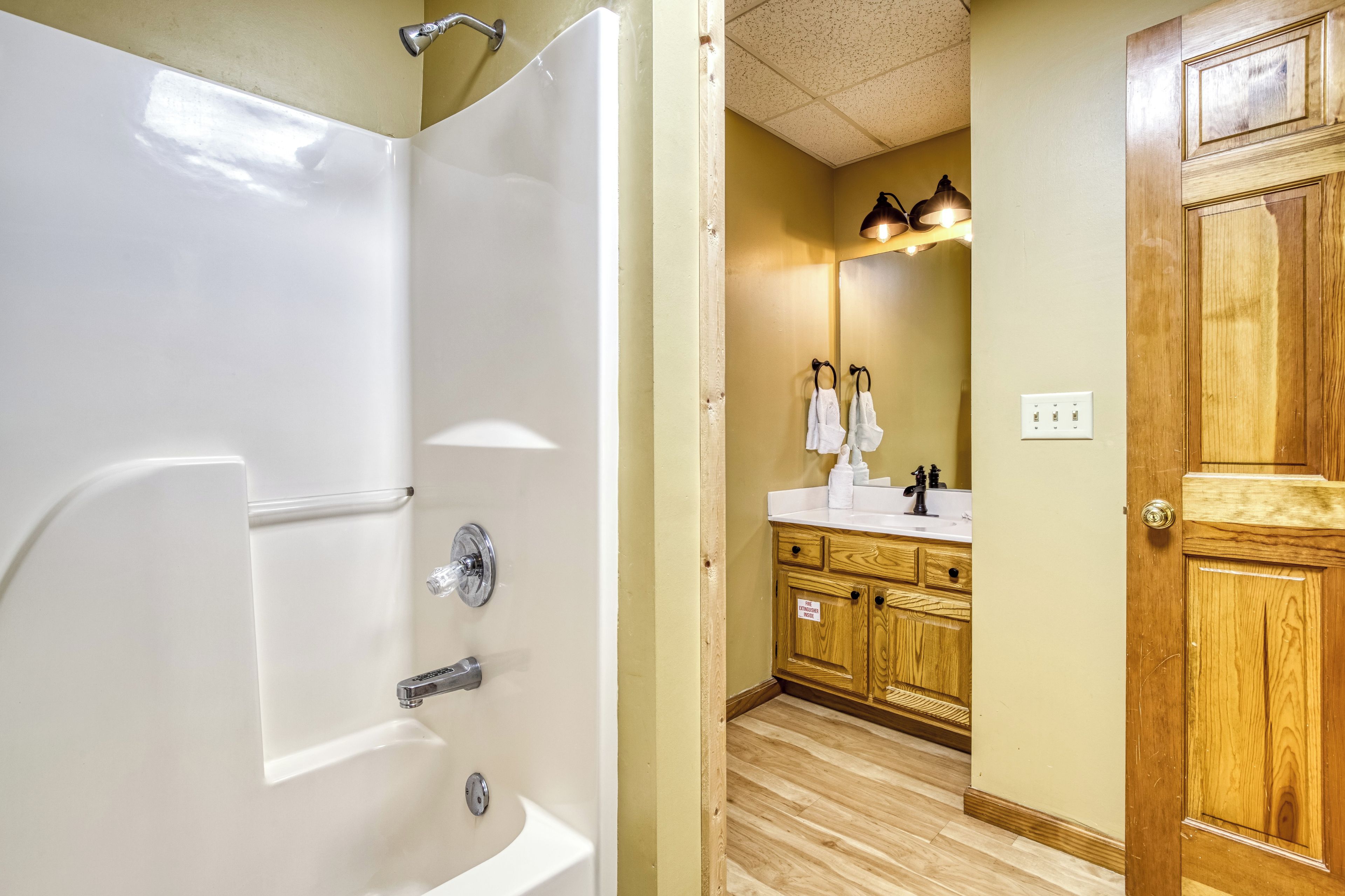 Un bagno con doccia, lavandino e mobili in legno.