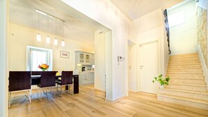 Un vaste espace de vie comprenant une table à manger, des chaises et un escalier menant à l’étage supérieur.
