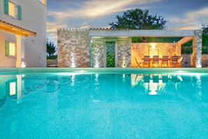 A swimming pool with a stone wall and a covered seating area. - Villa Demetra with infinity pool,8 persons, spectacular view of Motovun (Motovun)