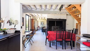 Un espace repas agrémenté d’une cheminée, d’un escalier et offrant une vue sur l’extérieur.