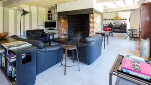 Un salon avec une cheminée, un ensemble de canapés, une table basse et une bibliothèque.