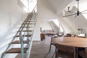 A modern interior with a staircase, a dining area, and a living space. - EMA House Serviced Apartments Unterstrass (Zürich)
