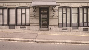 Fachada de un edificio con un letrero que dice 'EMA HOUSE SERVICES APTMENTS'.