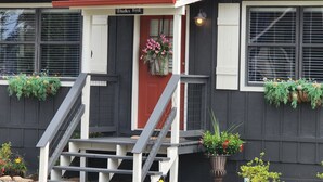 A building with a red door, a staircase, and flower boxes on the windowsills. - Creekside Cottages : Sneffles Mountain Luxury in Town (Blairsville)