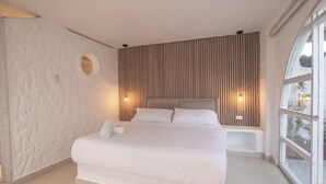 A modern bedroom with a large bed, a circular window, and a wooden slat wall. - 7 Bedroom Beautiful Mansion in the Old City (Cartagena)