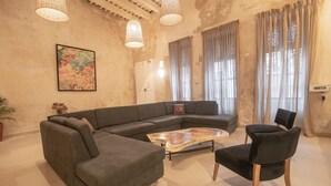 A living room with a sectional sofa, a coffee table, and a black chair. - 7 Bedroom Beautiful Mansion in the Old City (Cartagena)