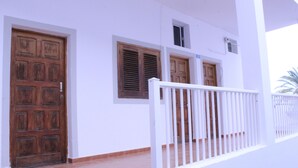A building with a white exterior, a wooden door, and a white railing. - Mele Sky Beach, 1, sea views, terrace and sun (Lomo Quiebre)