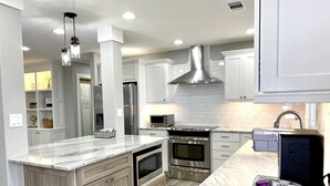 A modern kitchen with white cabinetry, a stainless steel range hood, a built-in oven, and a granite countertop. - Gorgeous Mountain View,  6 Private acres, Close to Downtown! (Hot Springs)