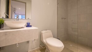 A bathroom with a white sink, a toilet, and a shower area. - 1 Bedroom Stunning Apartment in Bocagrande (Cartagena)