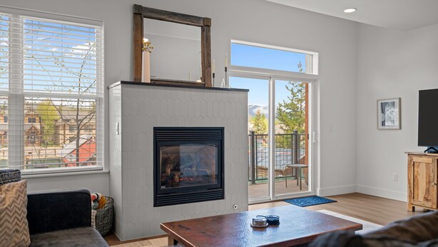 A modern living room with a fireplace, a sofa, a coffee table, and a television.