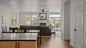 A spacious living area with a fireplace, a dining table with chairs, and a sofa.