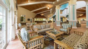 A spacious lobby with high ceilings, wooden beams, and a mix of seating areas including sofas and chairs.