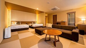 A hotel room with two beds, a sofa, a coffee table, and a desk with a lamp. - Inn Juraku Formerly Spa Riraku (Toon)