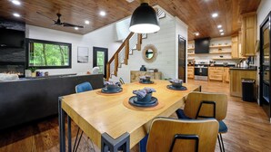Ein Holzinterieur mit Esstisch, Stühlen, Deckenventilator und Küchenzeile.