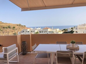 A terrace with a table and chairs, a potted plant, and a view of the sea and buildings. - ⭐ AMAZING DREAM SEA VIEW PENTHOUSE - 3 BEDROOMS ⭐ (Calahonda)