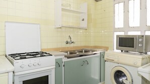 A compact kitchen with a gas stove, sink, microwave, and washing machine. - PROVENCE, 5º-17 (Cullera)