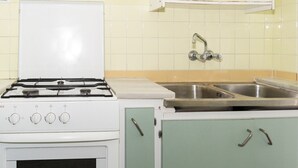 A kitchen with a white stove, a sink, and green cabinets. - PROVENCE, 5º-17 (Cullera)