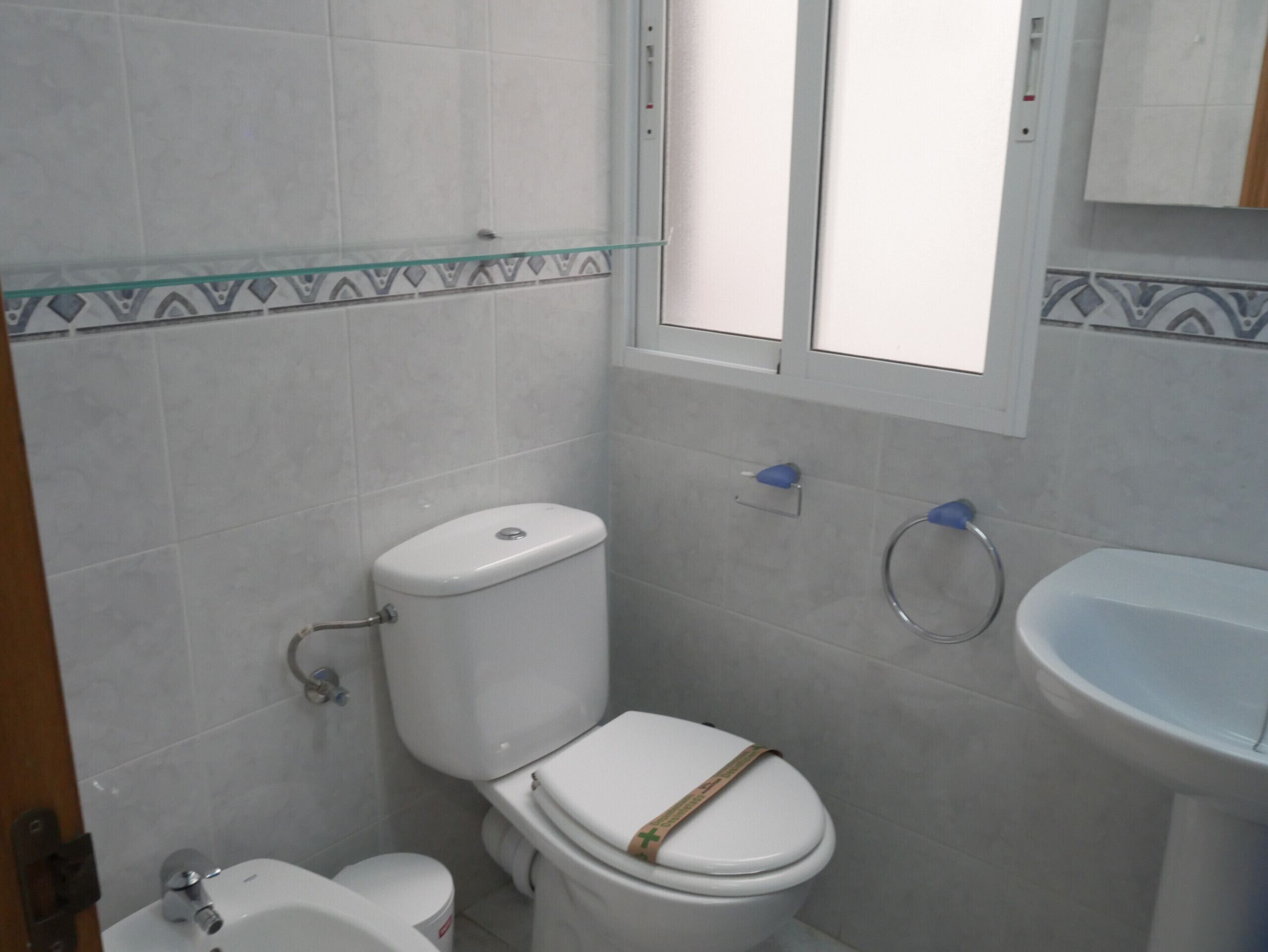 A bathroom with a toilet, bidet, and sink.