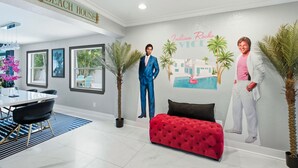 Ein modernes Interieur mit Essbereich, einer roten gepolsterten Bank und Wandgemälde.