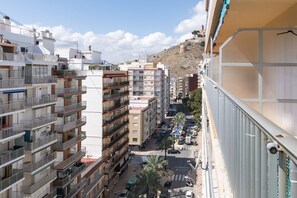 A multi-story residential building with balconies, a street view, and a hillside in the background. - MIRALMAR, 10º-69 (Cullera)