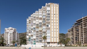 Een hoog hotel met meerdere balkons, een plat dak en een modern architectonisch ontwerp.