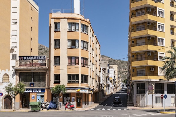 Um edifício de vários andares com fachada curva, uma vitrine visível com a placa