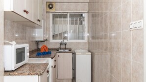 A compact kitchen with a microwave, sink, and small refrigerator. - ESTIRPE, 2º-4 (Cullera)