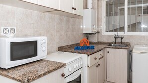 A kitchen with a microwave, stove, sink, and cabinets. - ESTIRPE, 2º-4 (Cullera)