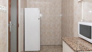 A small kitchenette with a white refrigerator, a microwave, and a granite countertop. - ESTIRPE, 2º-4 (Cullera)