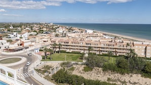 A coastal hotel with multiple buildings, a beach, and a roundabout. - DOSEL, 6º-30 PARKING 30 (Faro de Cullera)