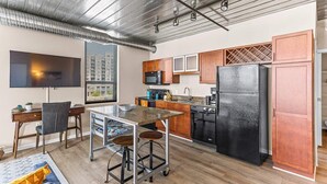 A modern kitchen with a large island, stainless steel appliances, and wooden cabinets. - Urban Condo with Balcony in Downtown Ann Arbor (Ann Arbor)