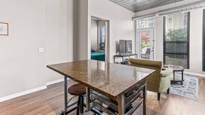 Une cuisine moderne dotée d’un plan de travail en granit, d’appareils électroménagers en acier inoxydable et d’un coin repas avec une table et des chaises.