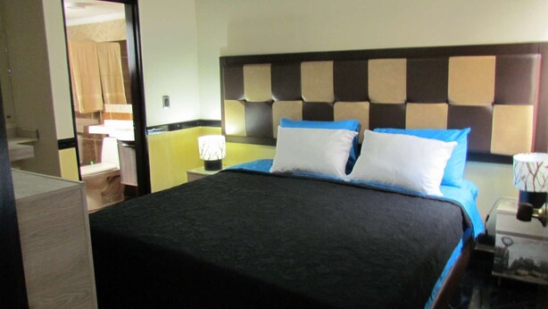A hotel room with a bed, a nightstand, and a lamp. - One Bedroom Loft AC Hot Tub APT 201 (Medellin)