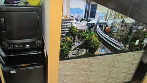 A room with a view of a cityscape, including a train and palm trees.