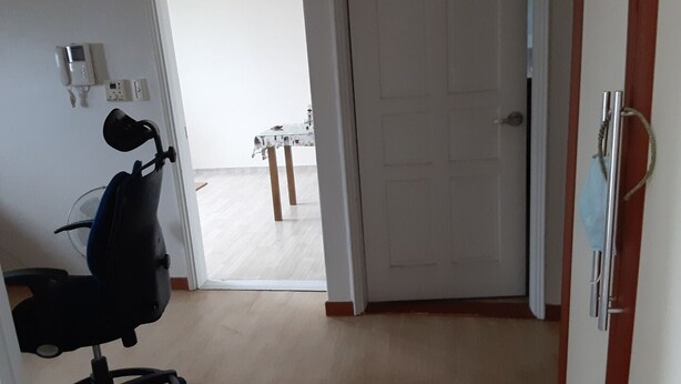 Una habitación con un escritorio, una silla y una puerta que da a otra estancia.