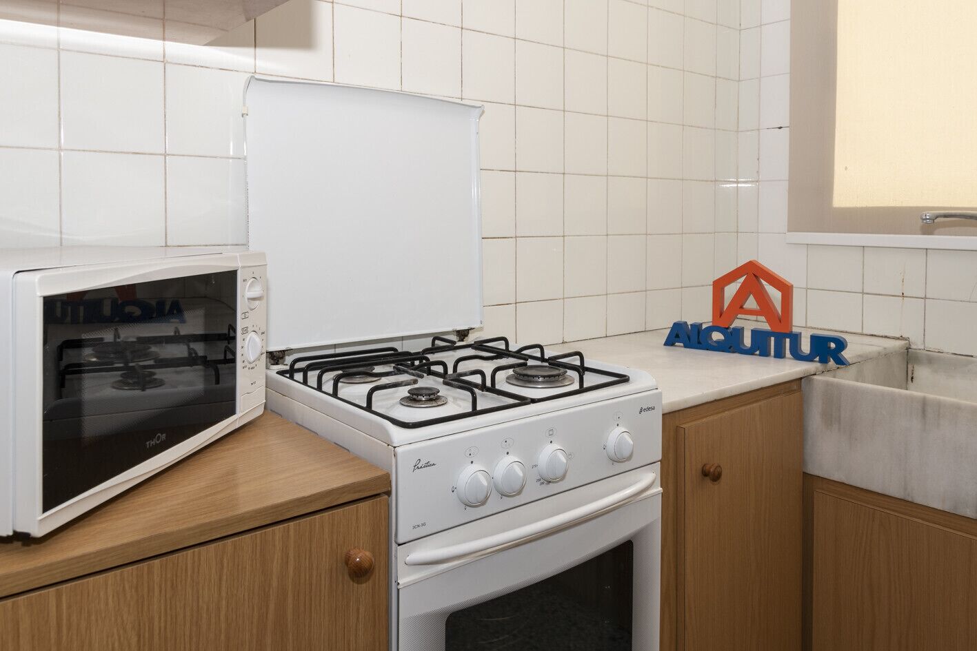 A kitchen with a white stove, a microwave, and wooden cabinets.