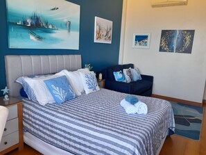 Une chambre à coucher comprenant un lit, une table de chevet, une commode et un canapé.
