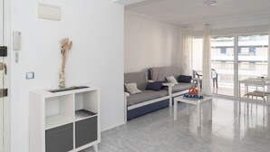 Ein modernes Wohnzimmer mit einer Couch, einem Couchtisch und einem weißen Schrank.