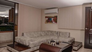 Una sala de estar moderna con un sofá seccional gris, una mesa de centro y un cuadro en la pared.