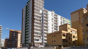 A multi-story residential building with balconies, a street in front, and a clear sky. - MONTEMAR, C-8º-22 (Cullera)