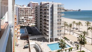 A high-rise hotel with multiple balconies, a pool, and a beach view. - MONTEMAR, C-8º-22 (Cullera)