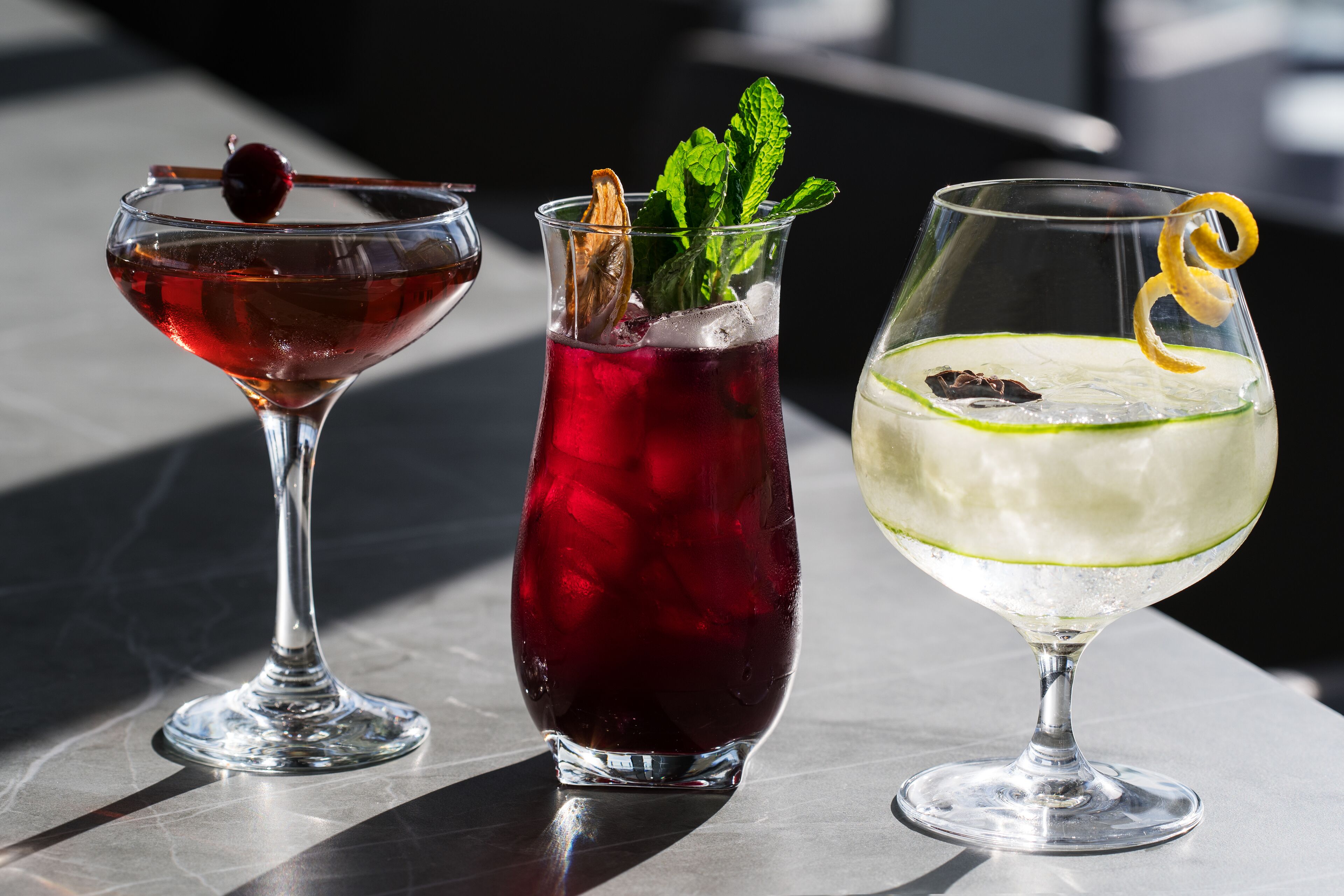 Three different types of drinks in glasses on a table.